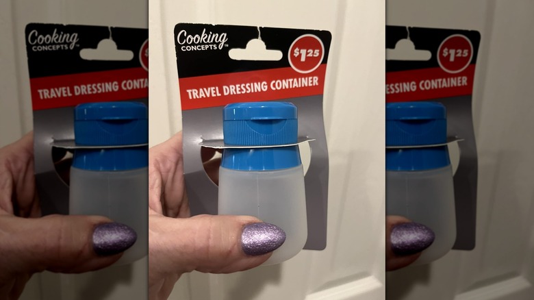 Hand holding salad dressing container