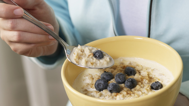 Woman eating bowl of oatmeal