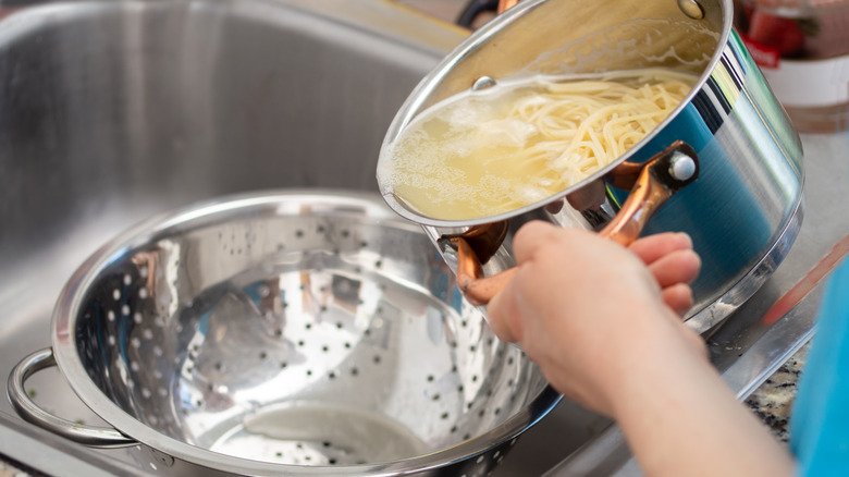 Draining pasta water into the sink