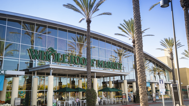 A modern Whole Foods with palm trees and outdoor seating