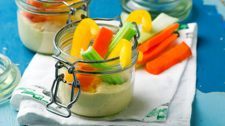 small jar with dip at bottom and veggies