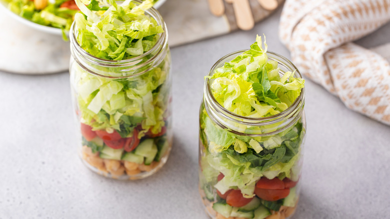 2 mason jars filled with veggies and chickpeas