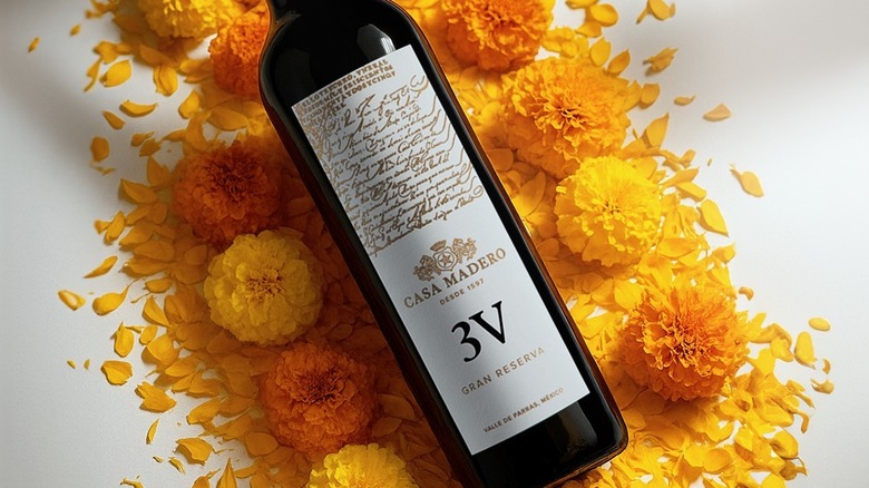 A bottle of Casa Madero 3V with marigold blossoms