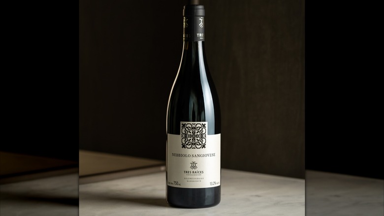 A bottle of Tres Raíces Nebbiolo Sangiovese on a table