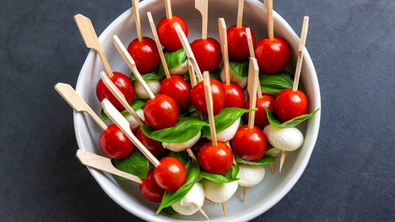 Caprese skewers are made of cherry tomatoes, mozzarella, and basil.