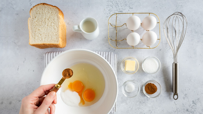 French toast ingredients like bread, eggs, and milk are neatly arranged on a counter.