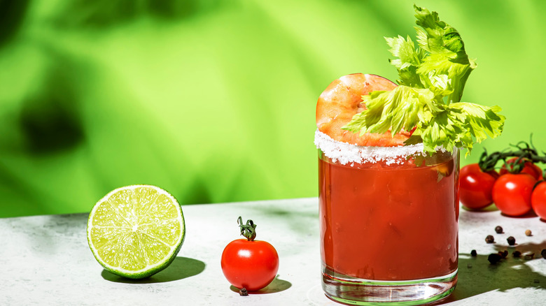A bloody Mary has been garnished with shrimp.