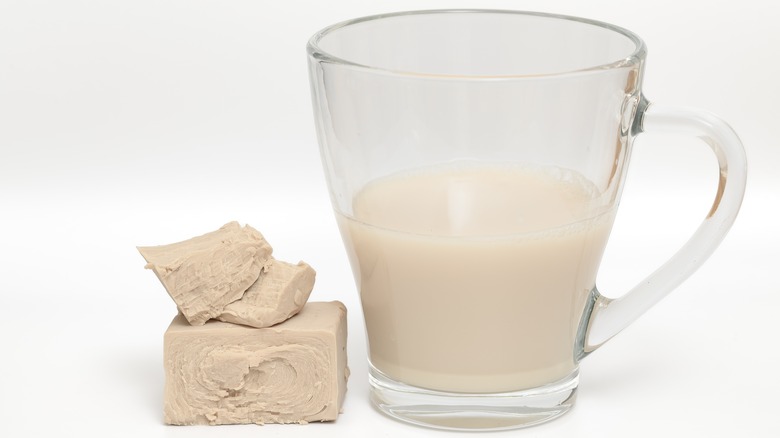 Block of fresh yeast besides a pitcher of dissolved yeast