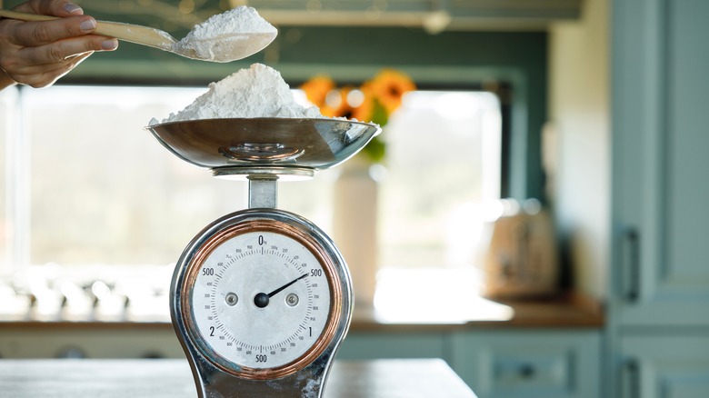 Woman measuring flour on antique scale