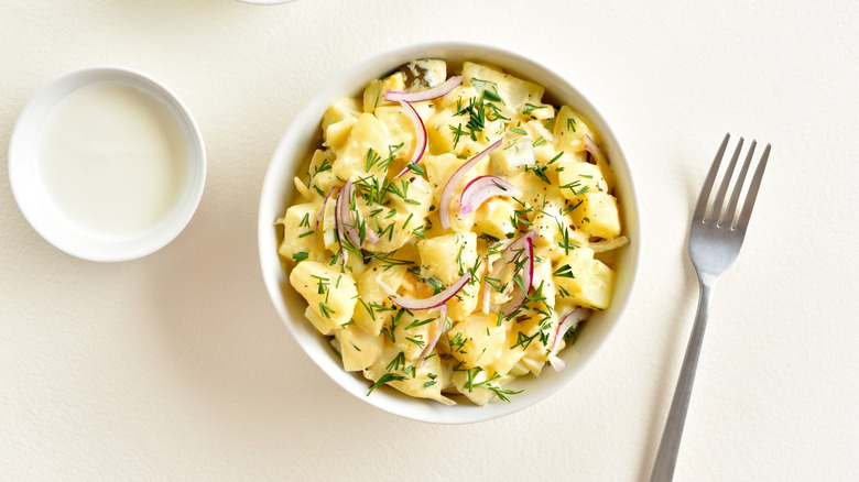 bowl of potato salad with onions on top