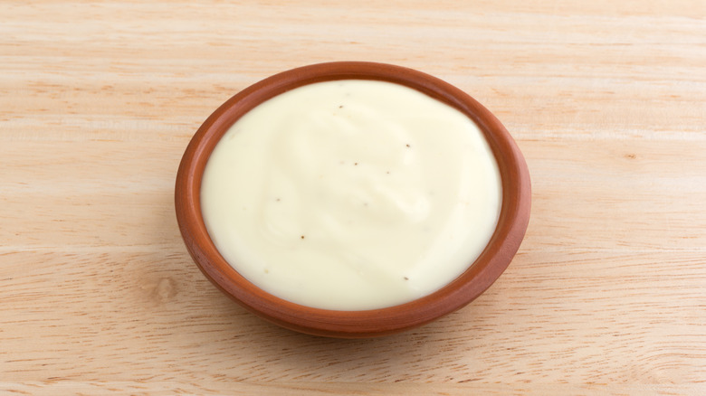 small dish filled with blue cheese dressing on wooden surface