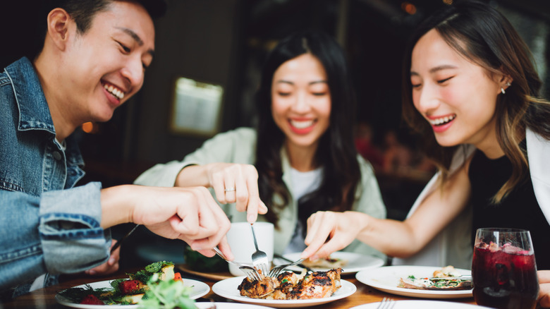 Group of people sharing food from plate