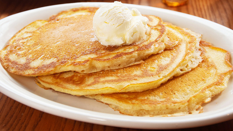 up-close of pancake stack with whipped butter on top