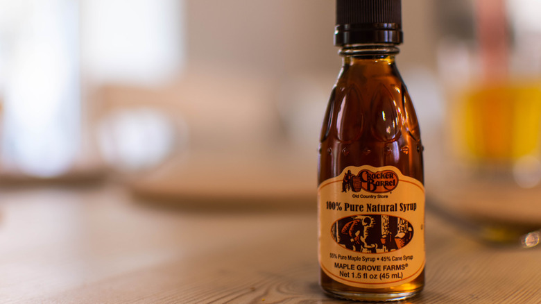 Small bottle of Cracker Barrel Pure Natural Syrup on a wooden table
