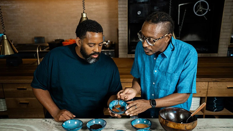 Chef Gregory and his partner spooning ground coffee out of a bowl