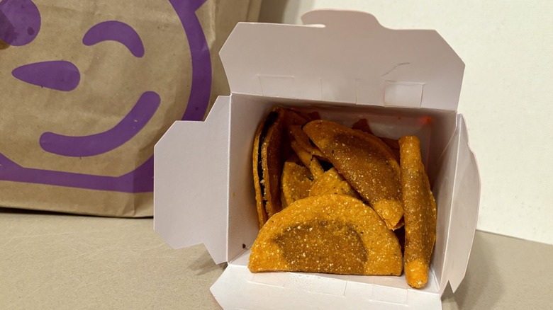 Birria tacos in their box next to a Jack in the Box bag