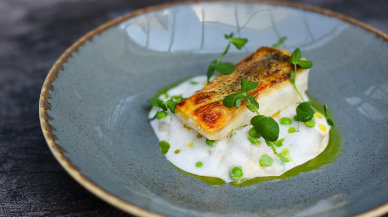 Plate of fish with cream and greens
