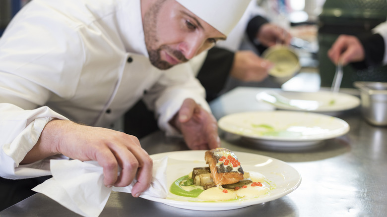 Person cleaning up a plate in a restaurant