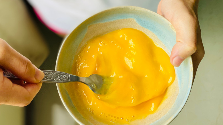 Person beating eggs in bowl
