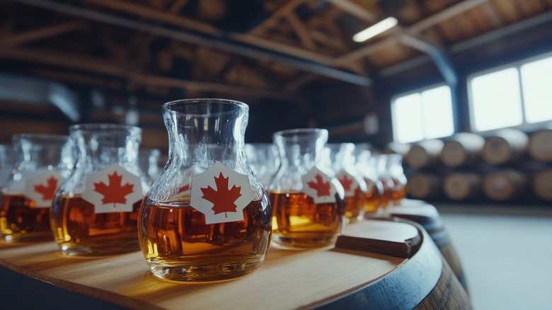 Numerous glass containers of maple syrup with Canadian flag stickers on them