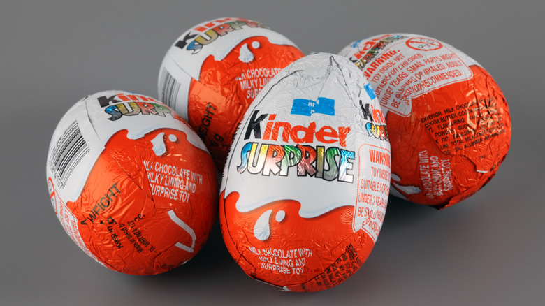 Four Kinder Surprise Eggs on a gray background