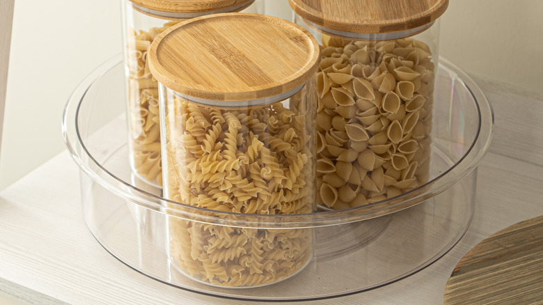 A clear lazy susan with storage containers inside