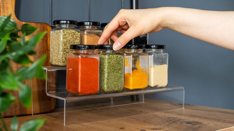 Glass spice jars on an acrylic shelf riser