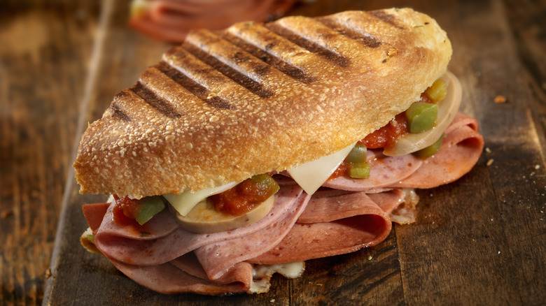 A pressed panini with meat, cheese, and vegetables
