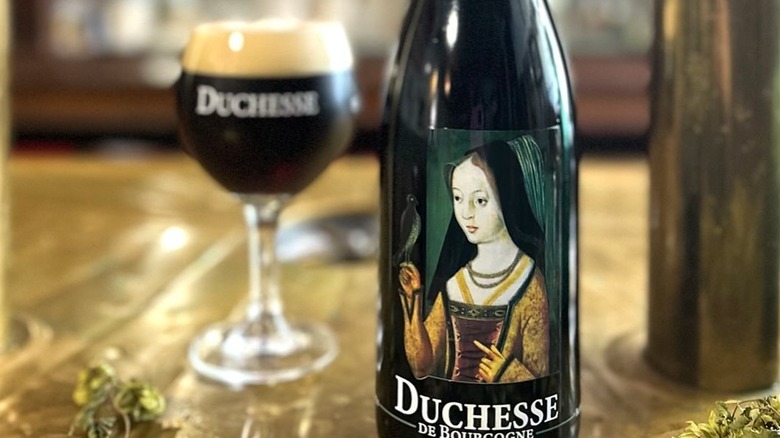 Duchesse de Bourgogne bottle and filled glass sit on a table.