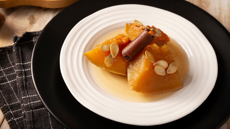 A plate of calabaza en tacha garnished with a cinnamon stick