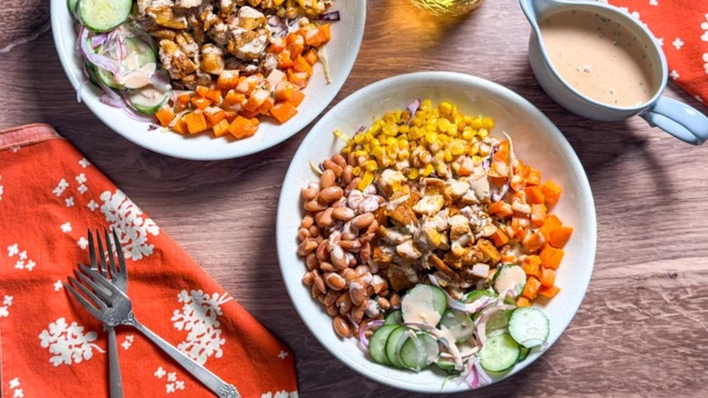 a bowl of BBQ chicken with coleslaw, sweet potatoes, and other fixings