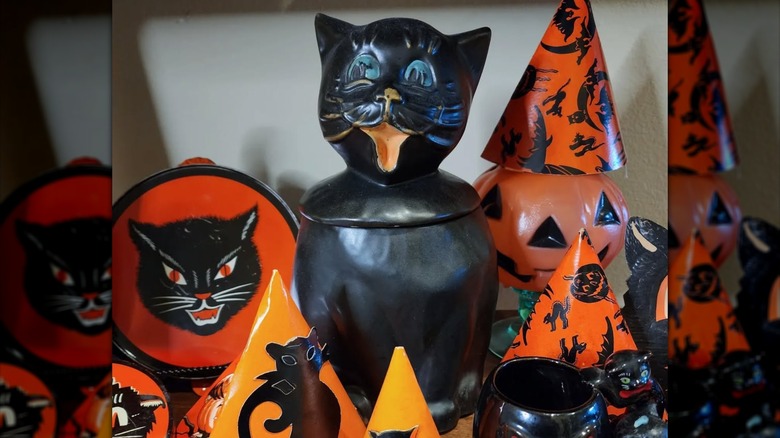 Vintage black cat cookie jar next to other Halloween decor