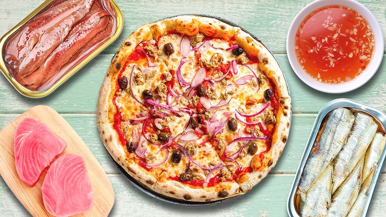 Pizza with seafood items in background
