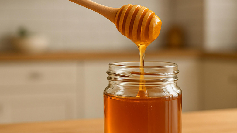 Honey is poured into a small jar