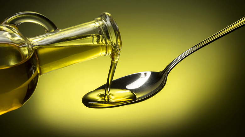 Olive oil is poured onto a spoon