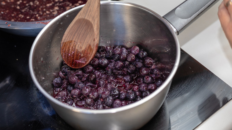 Blueberries in a pot begin to reduce on a stovetop