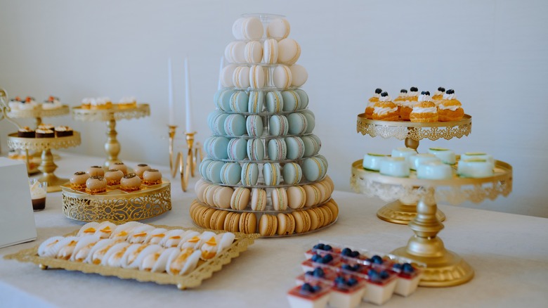 A dessert spread with a tower of macarons and pastries