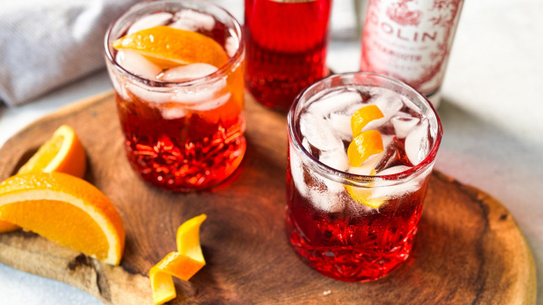 two americano cocktail on wooden cutting board with orange slices