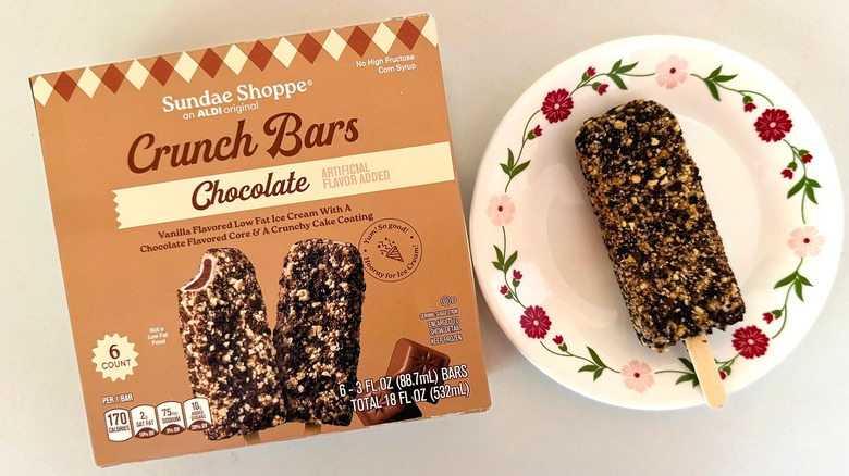 Box of Sundae Shoppe Chocolate Crunch Bars beside one ice cream bar on white dish