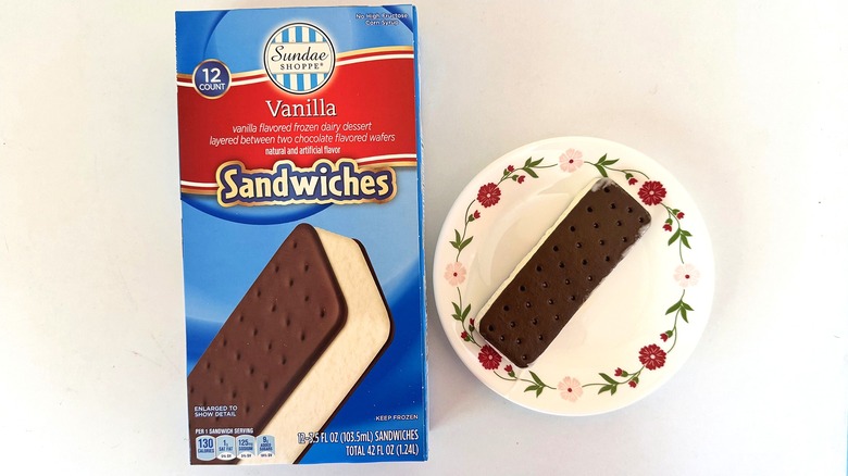 Box of Sundae Shoppe Vanilla Sandwiches beside one ice cream bar on white dish