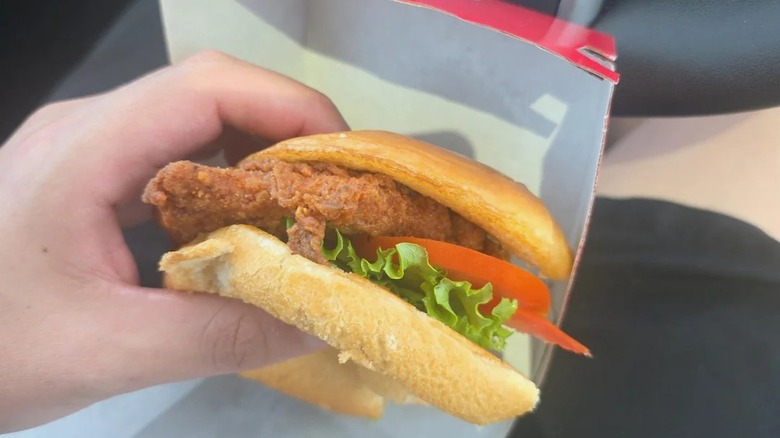 A person holding a Chick-fil-A chicken sandwich