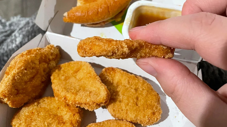 A person holding a McNugget from mcDonald's