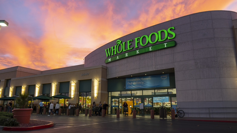 The exterior of Whole Foods Market with a sunset behind the building