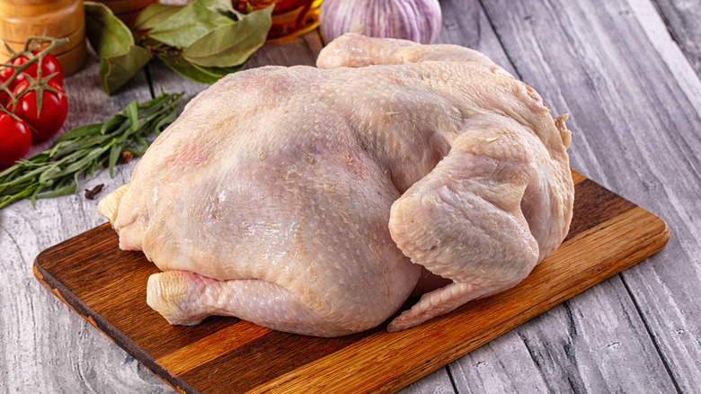 Whole raw chicken on a cutting board