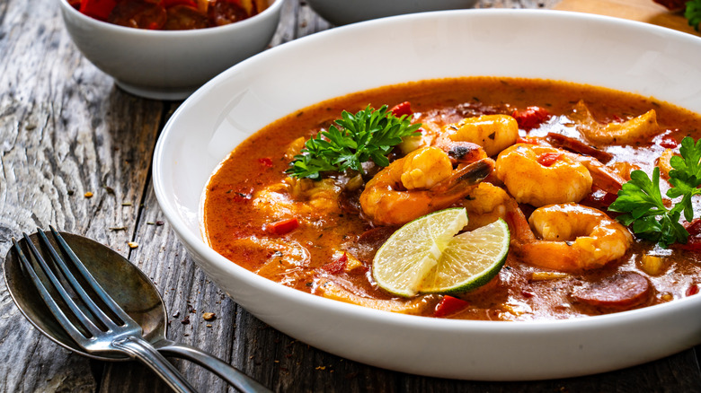 A bowl of Louisiana gumbo served with a fork and spoon