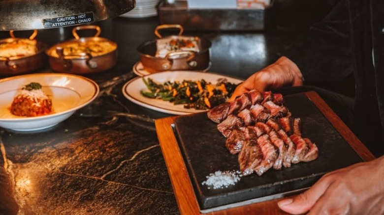 Hands holding the steak sampler at Born & Raised