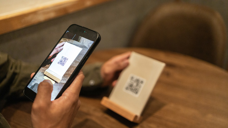 Person scanning menu QR code in a restaurant