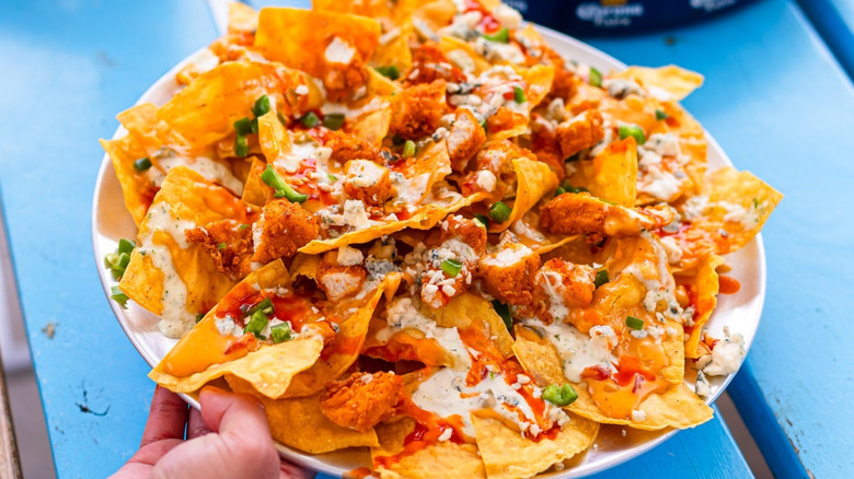 A person holding a plate of nachos at Rusty Taco