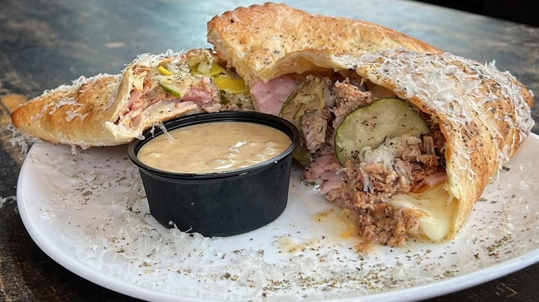 A calzone cut in half on a plate with honey mustard at Sauce on the Side