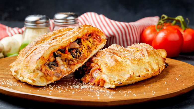 A calzone cut in half on a wooden cutting board at Simple Simon's Pizza